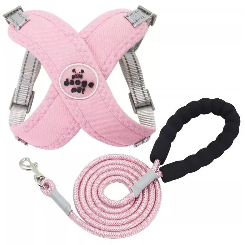 Pink dog vest harness with attached hand holding rope on a white background