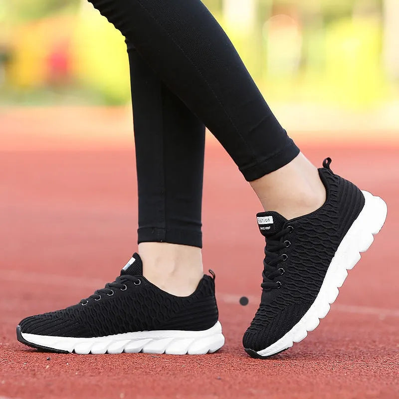 Women's running shoes with fly weaving upper in black, pink, or white colours, showing durable outsole.