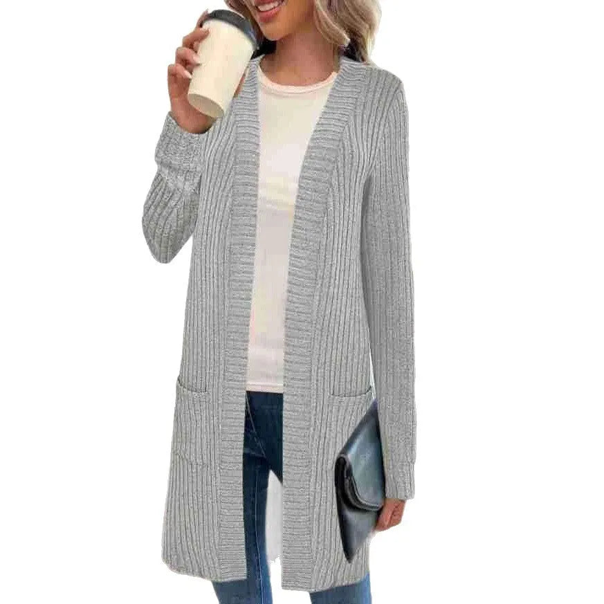 Loose fit grey knitted cardigan jacket with long sleeves and patch pockets on a hanger.