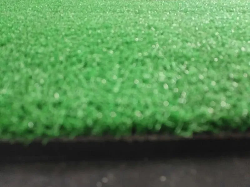 Green golf swing practice mat made of rubber and nylon, 15mm thick, on a driving range surface