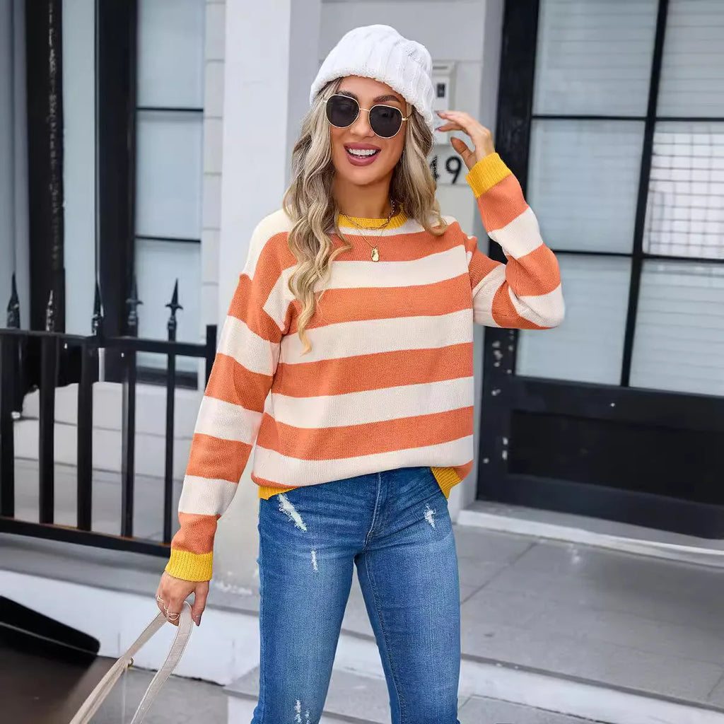 Blue striped women's loose-fit long sleeve acrylic sweater on a hanger.
