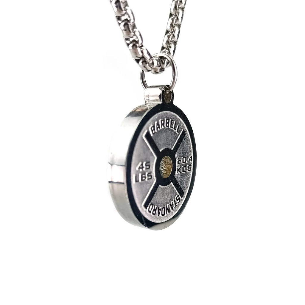 Polished stainless steel barbell disk geometric pendant necklace on a gold chain.