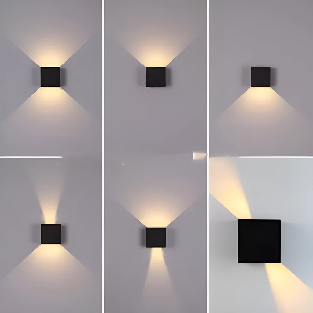 Small square aluminium wall lamp in black, mounted on a corridor wall, emitting a warm white light.