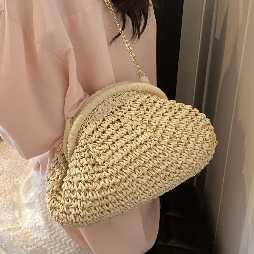 Women's woven straw shoulder bag with shell shape in khaki colour featuring chain detail