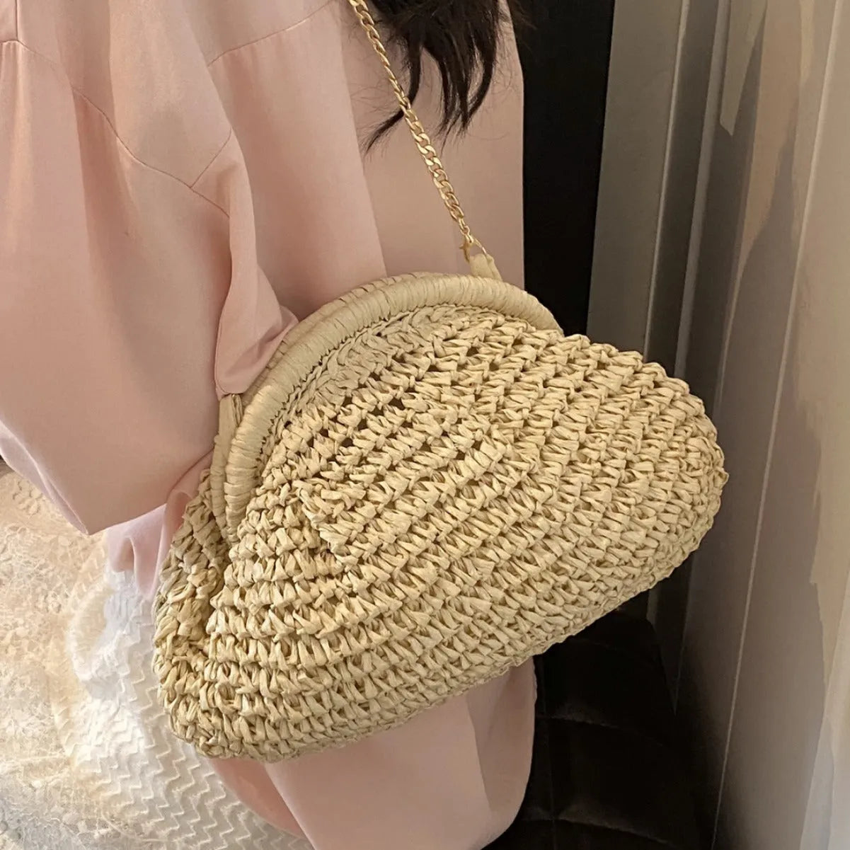 Women's woven straw shoulder bag with shell shape in khaki colour featuring chain detail