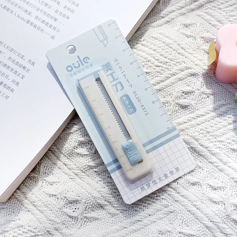 Small plastic art knife in blue, shown next to a ruler showing its 7.2 cm length.
