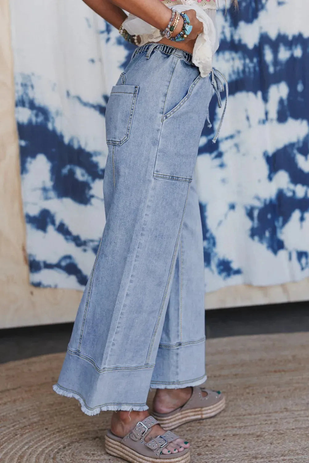 Beau blue wide leg denim pants with elastic drawstring waist and raw hem finish laid flat