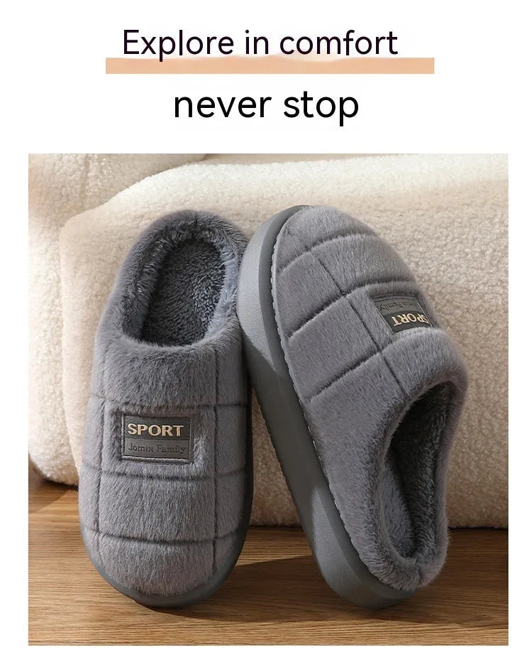 Men's grey and brown plaid rabbit hair winter slippers with a thick sole on a wooden floor.