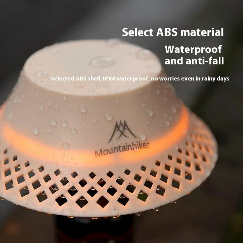 Beige and grey wine bottle shaped camping lantern with USB-C port on a wooden table.