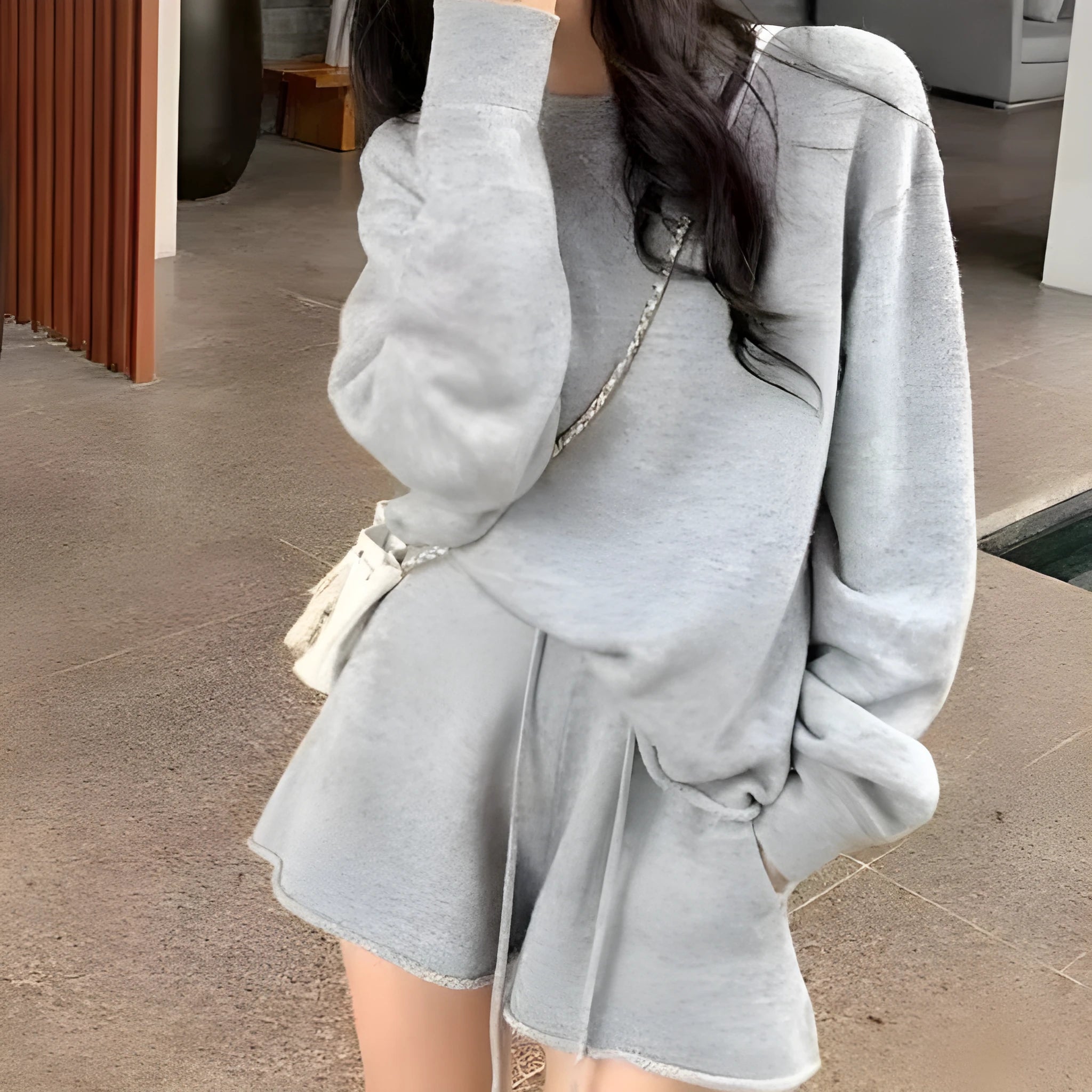 Women's loose-fitting knitted two-piece set showing long sleeve sweater and wide leg shorts in oatmeal colour