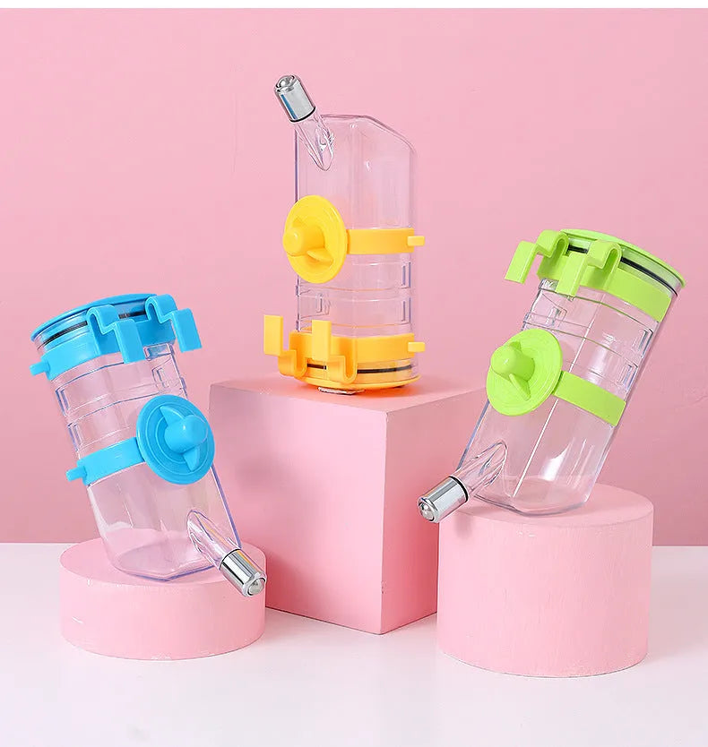 No drip dog kennel water bottle dispenser with dripless nozzle, hanging in a crate, available in blue, green, pink, and yellow