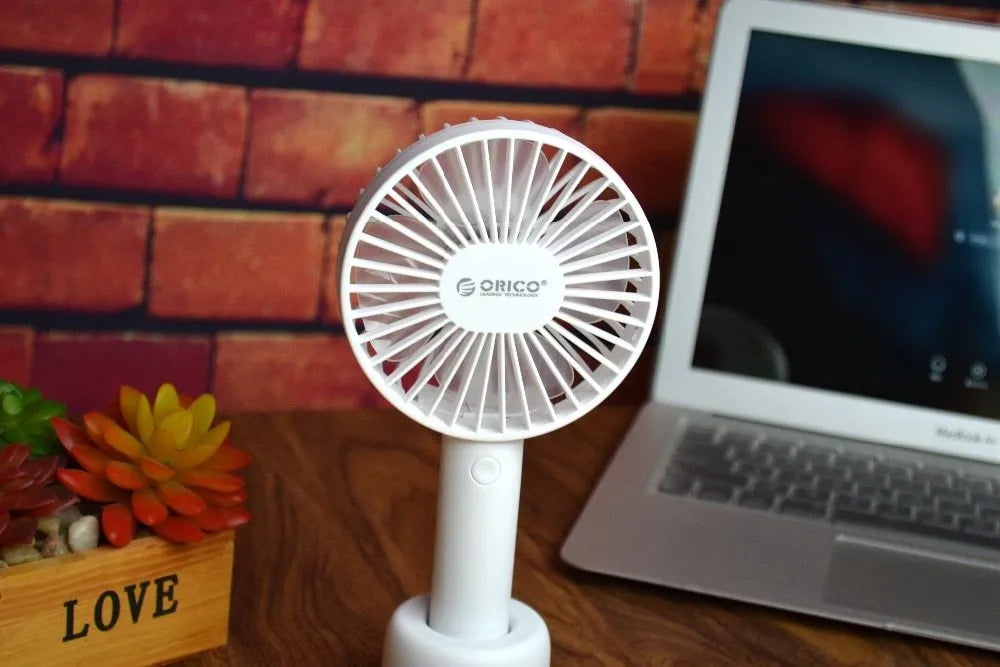 White ORICO FH1 USB rechargeable portable fan with fine-line texture on desk.