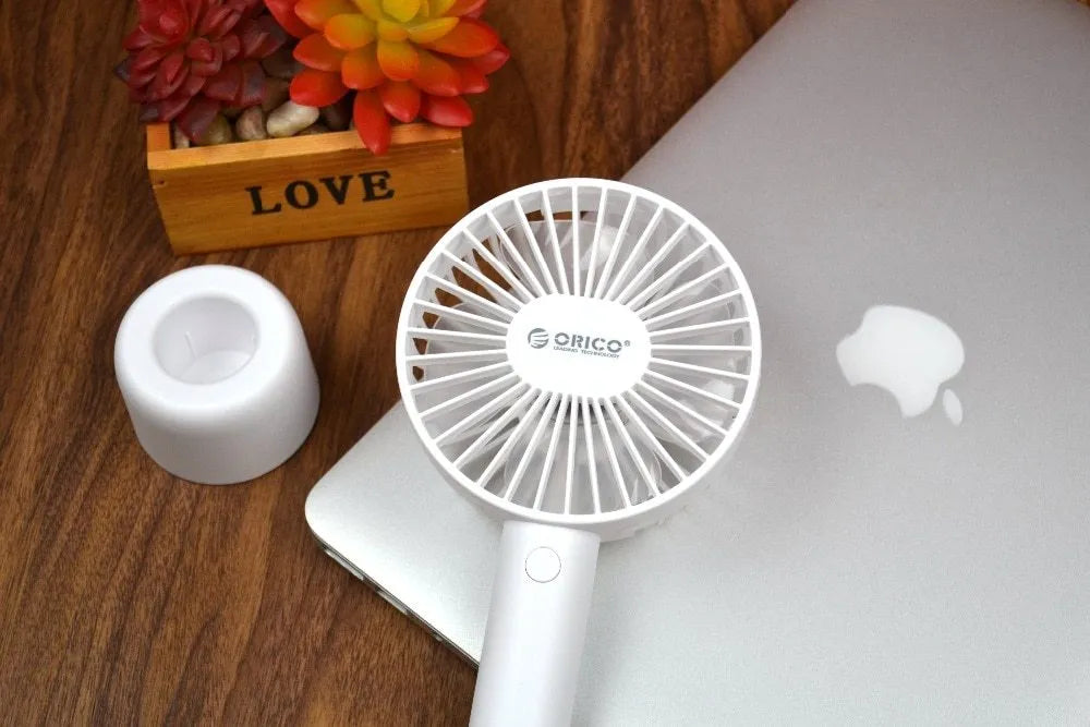 White ORICO FH1 USB rechargeable portable fan with fine-line texture on desk.