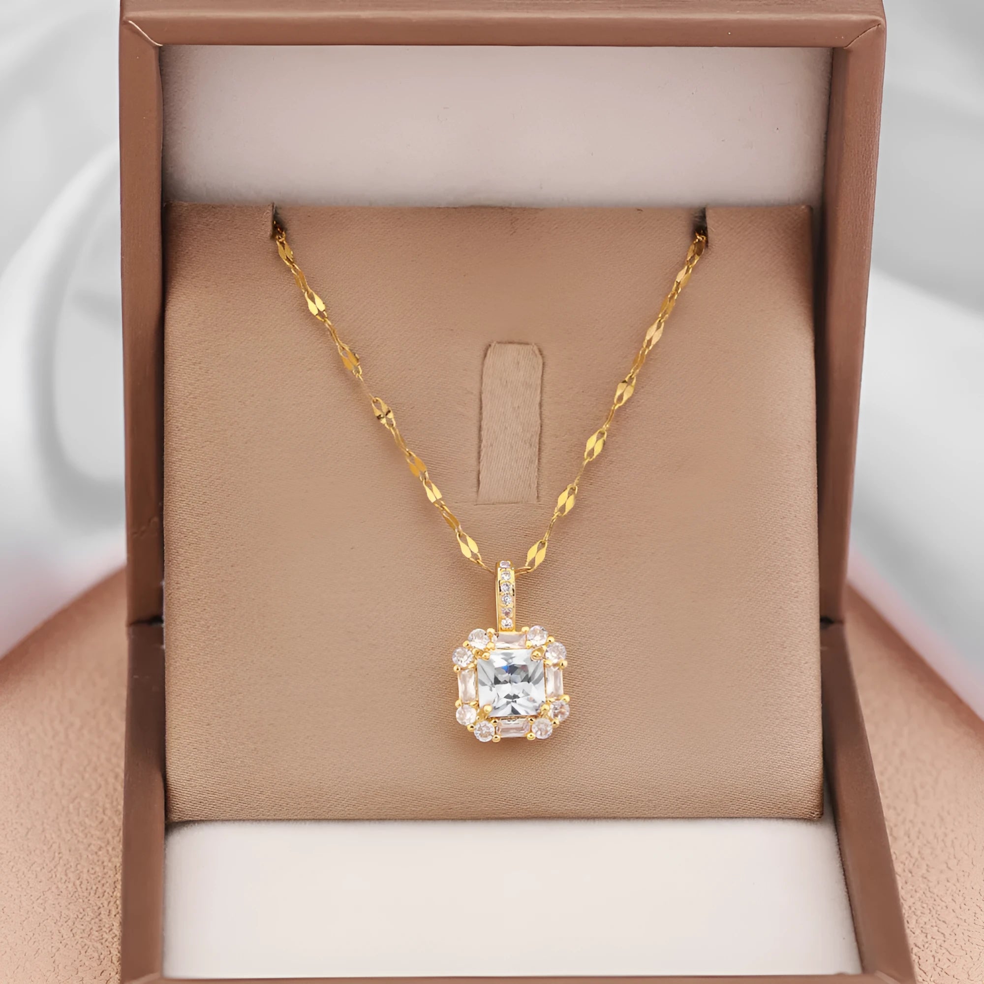 Gold geometric quadrilateral pendant necklace with mixed gemstones on a water wave chain.