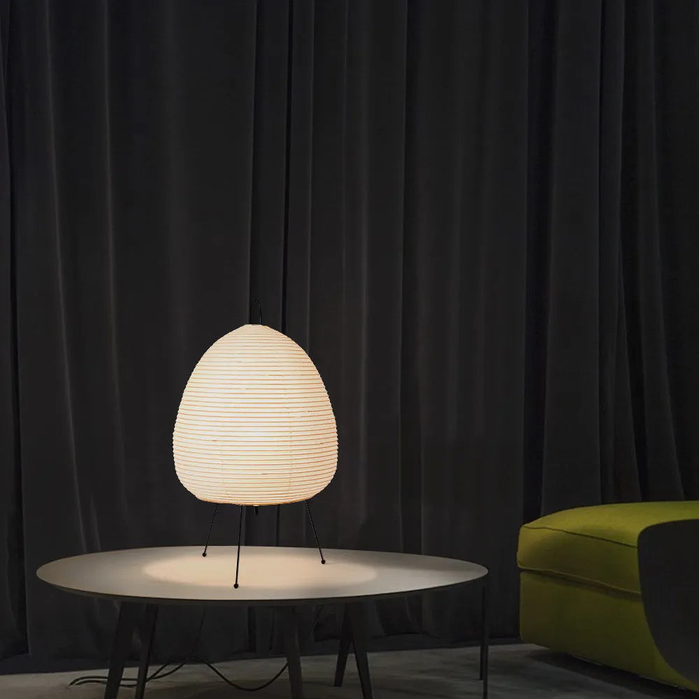 Japanese style table lamp with handmade paper shade and aluminium base on a wooden surface.