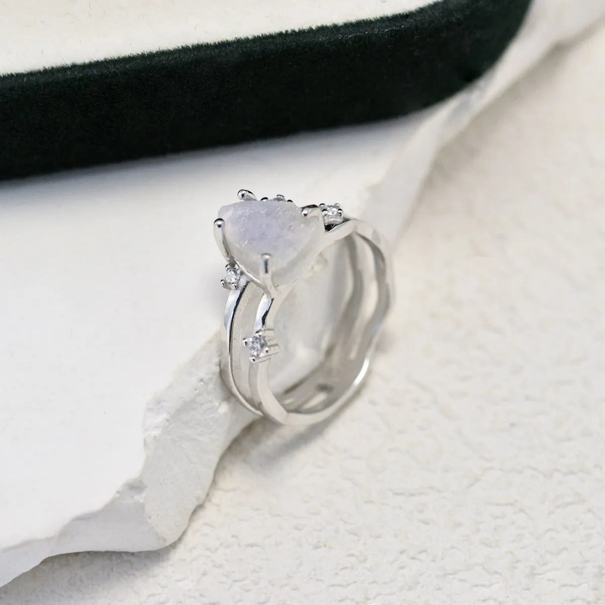 S925 sterling silver ring with irregular triangle design holding a moonstone, shown in rose gold plating.