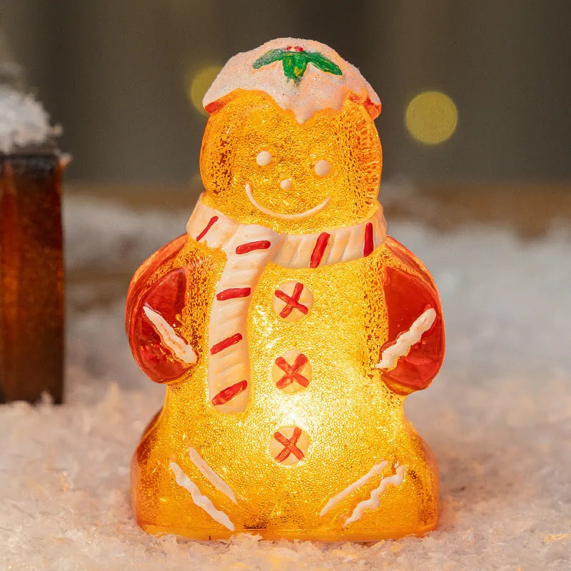 Glowing LED gingerbread man and snowman Christmas ornaments with coloured scarves on a festive tree branch.