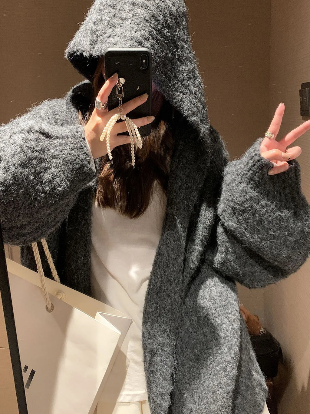 Woman wearing a brown retro-style Maillard hooded cardigan with a thick knit and loose fit.