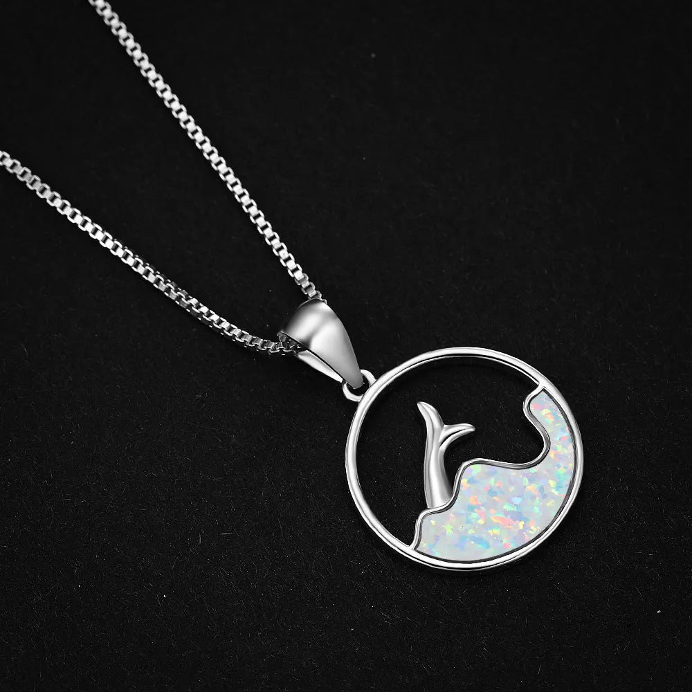 White gold electroplated sea fishtail necklace with a round blue opal pendant on a chain.