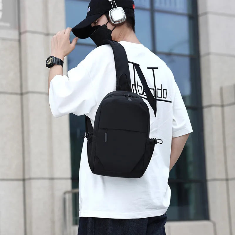 Grey men's waterproof chest bag shown on shoulder, displaying its 33cm height and spacious main compartment.