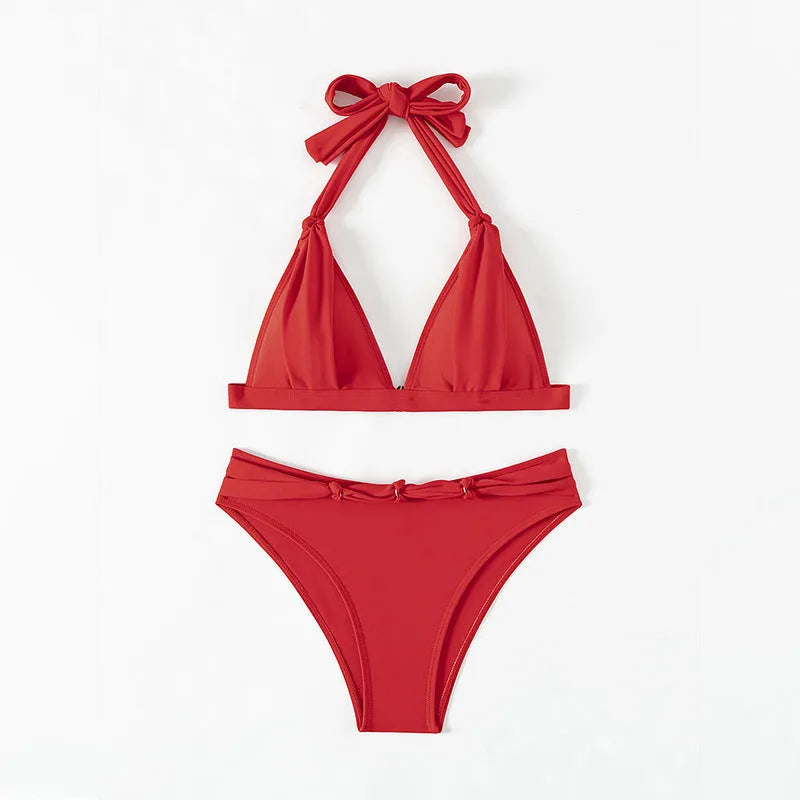 Red women's bikini set with lace-up halterneck top and matching split shorts on a mannequin.
