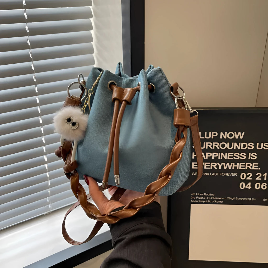 Blue cross body bucket bag with synthetic leather lining and hanging drop ornaments