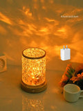 Small rotating water ripple night light on a solid wood base with touch control.