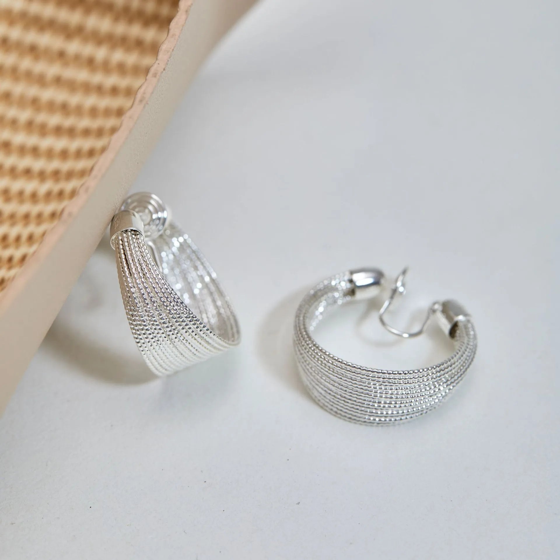 Set of geometric multi-layer earrings in gold and silver, showing stud and clip styles on a flat surface.
