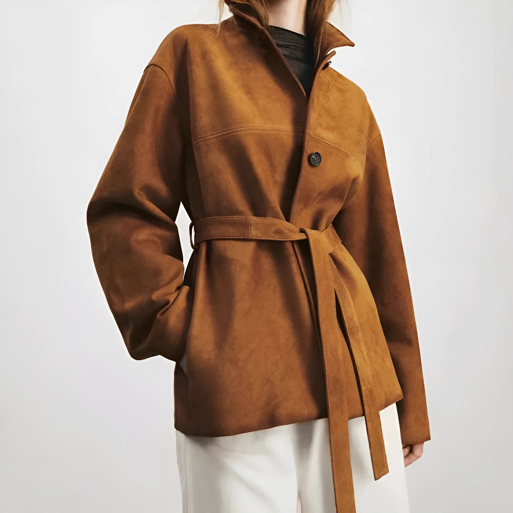 Yellow brown retro cashmere coat with Peter Pan collar, leather stitching, and a belt on a hanger.