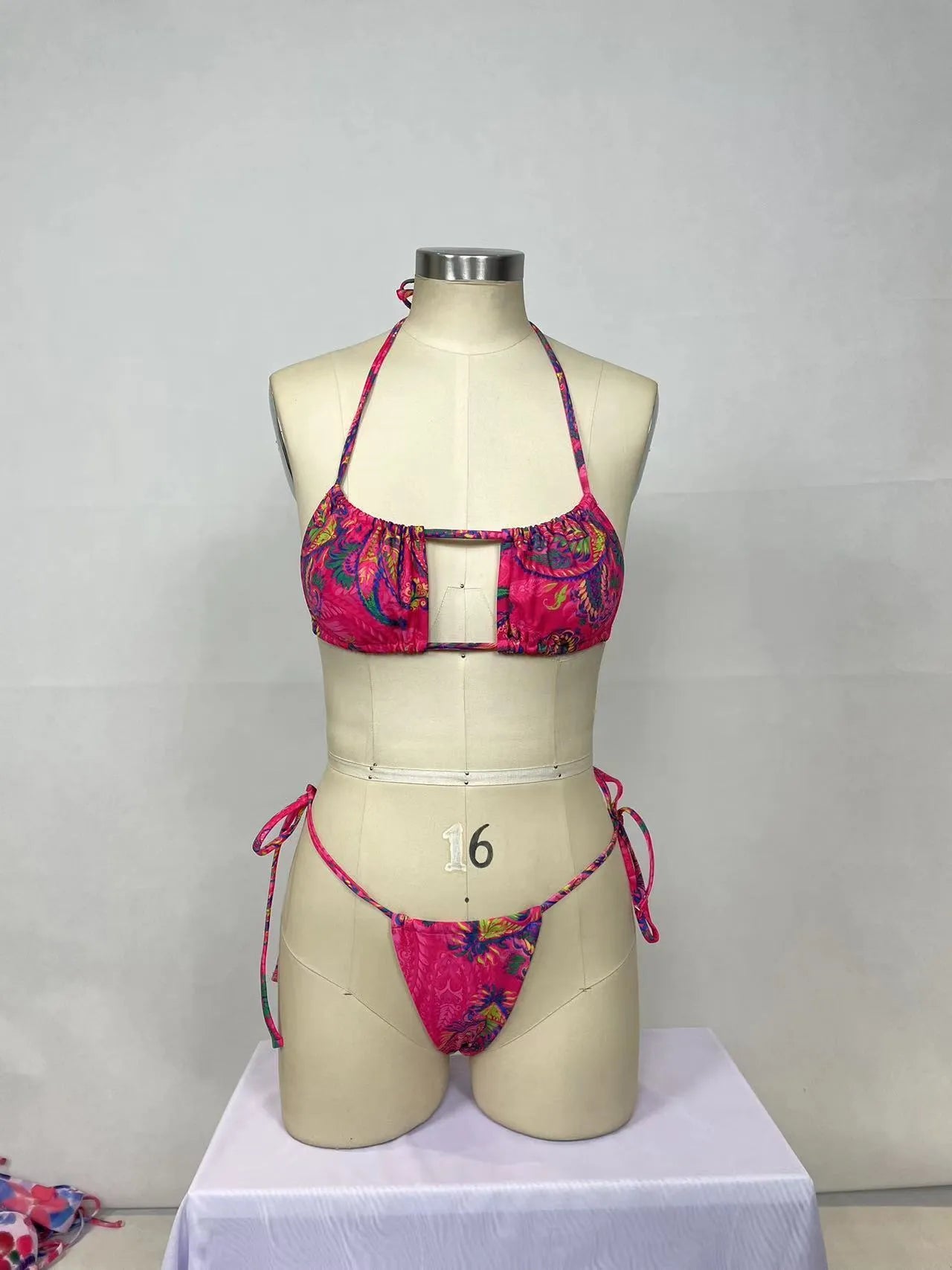 Women's pink printed bikini two-piece set with triangle top and briefs on display
