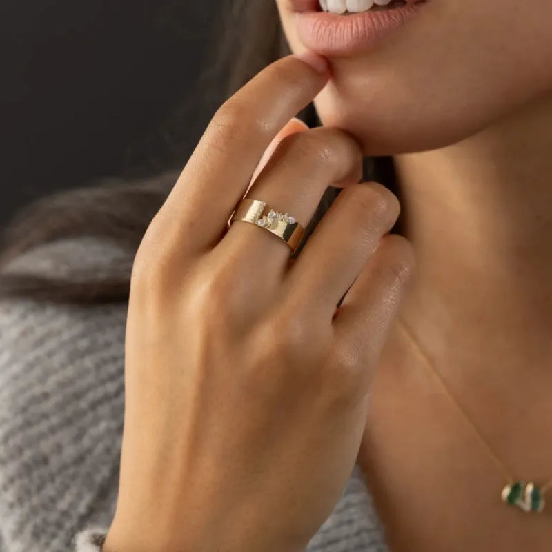Gold electroplated women's ring with shining zircon stones on a copper band.