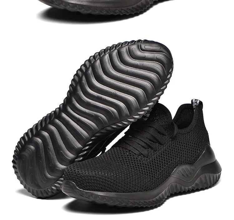 Steel toe cap safety work shoes in black with low-cut design, shown on a work site background.