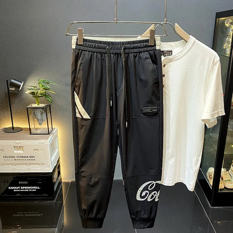 Men's solid black cropped trousers with banded ankles made from ultra-thin ice silk and cotton blend fabric.
