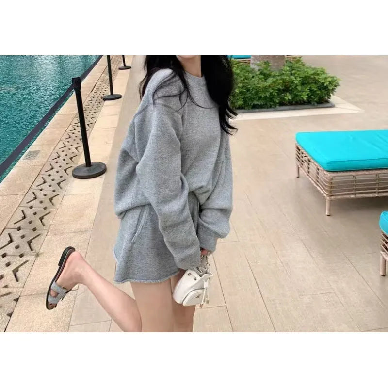 Women's loose-fitting knitted two-piece set showing long sleeve sweater and wide leg shorts in oatmeal colour