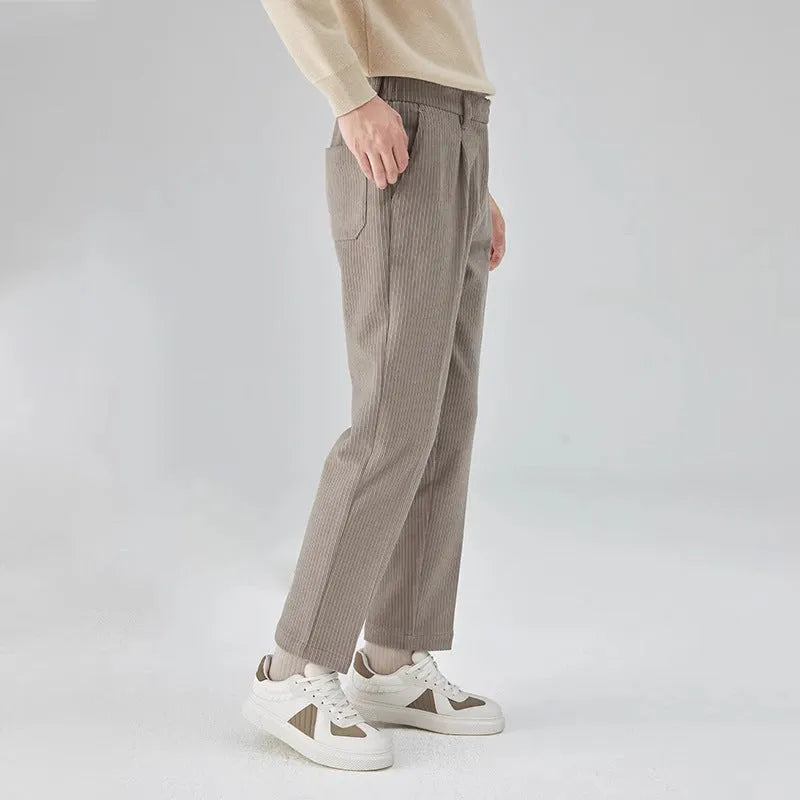 Men's straight-leg corduroy trousers in beige on a hanger, showing the textured fabric and mid-waist design.