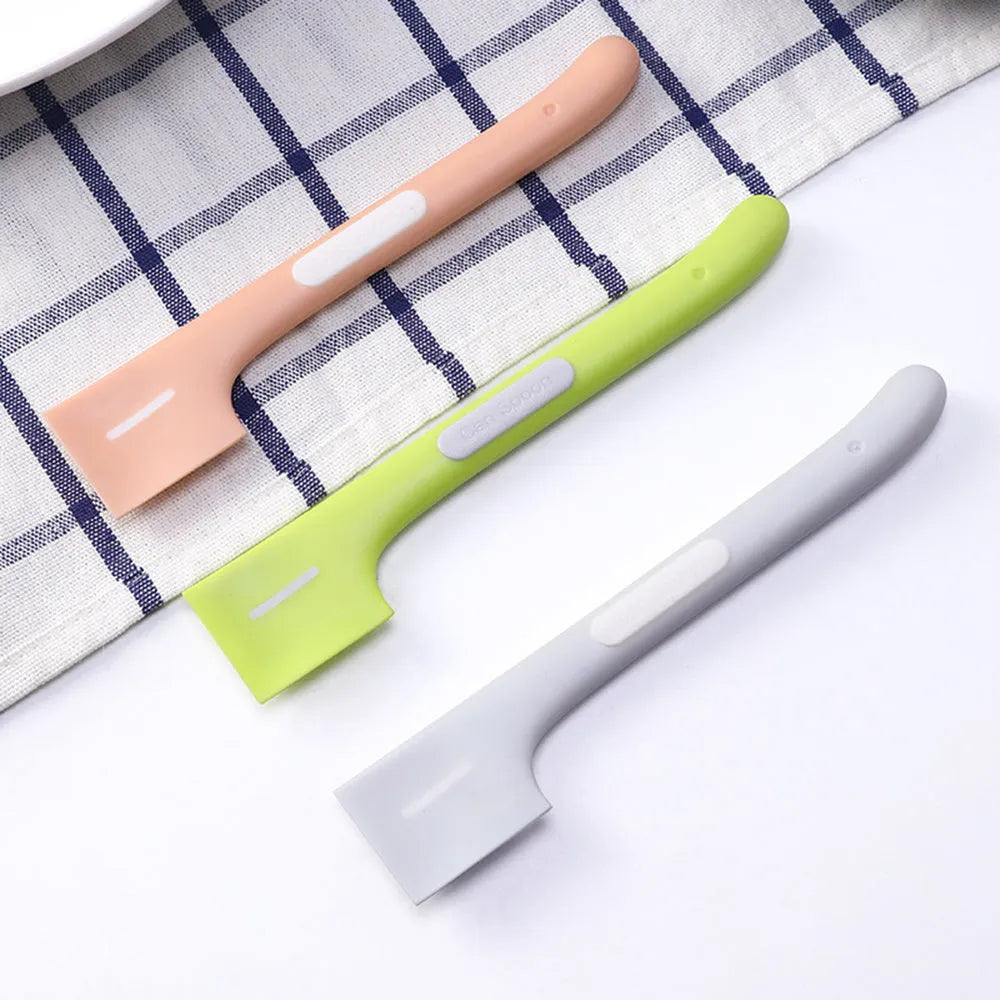 Green long-handled pet food spoon with right-angle head for scraping canned wet food.
