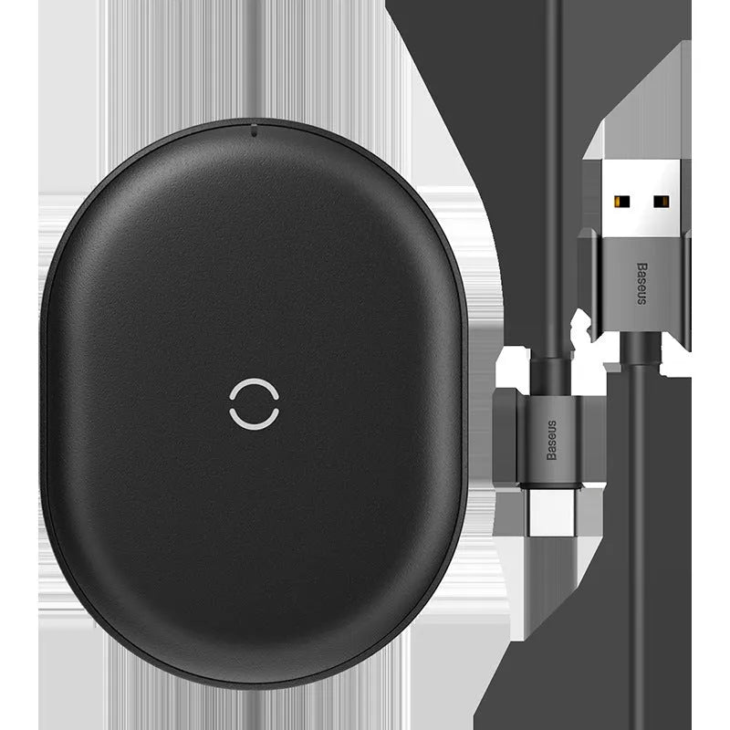 Black Baseus wireless charging pad with a textured surface and a small LED light, next to a mobile phone.