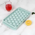 Blue silicone ice cube tray with lid showing round 33-grid design for homemade ice spheres