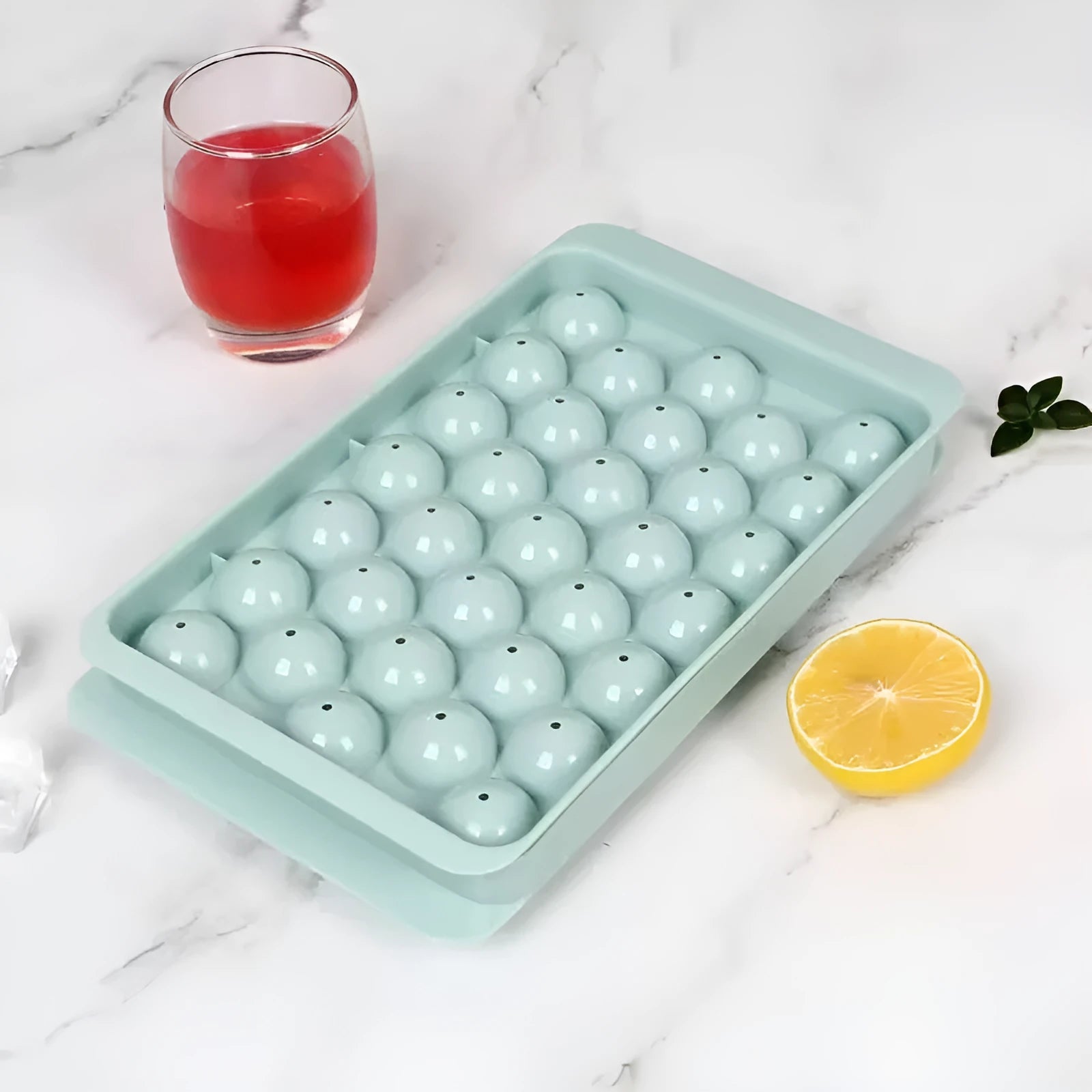 Blue silicone ice cube tray with lid showing round 33-grid design for homemade ice spheres
