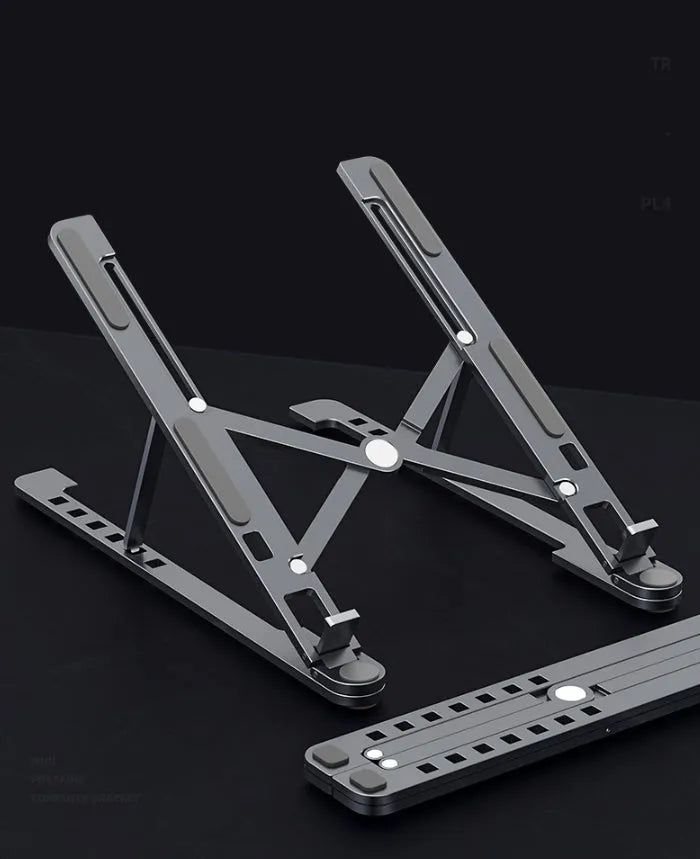 Portable aluminium laptop stand folded flat next to an open laptop showing its adjustable height.