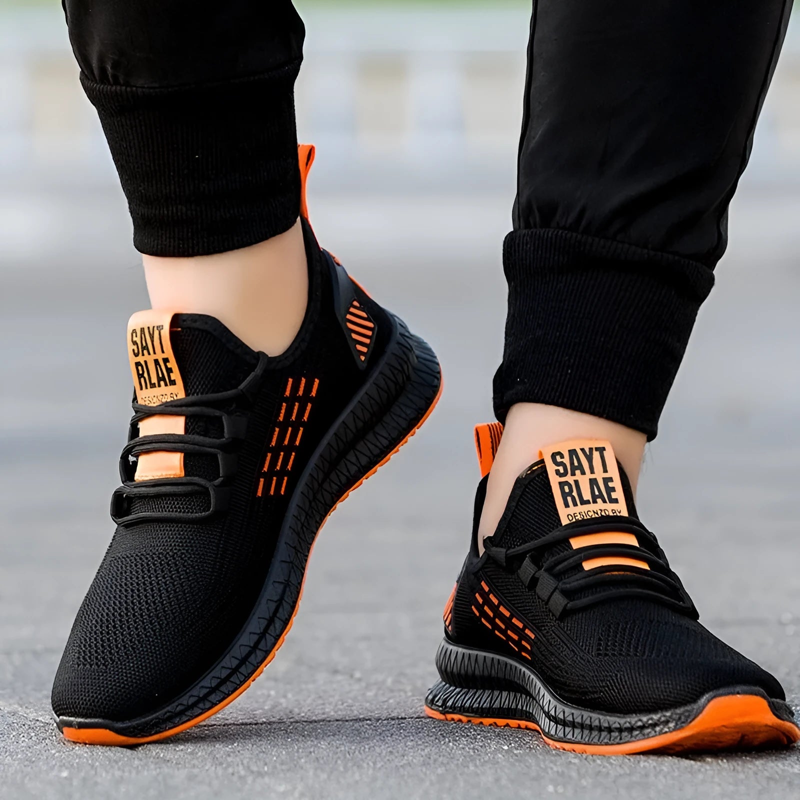 Men's black casual trainers with cross strap design on a flying weave upper.