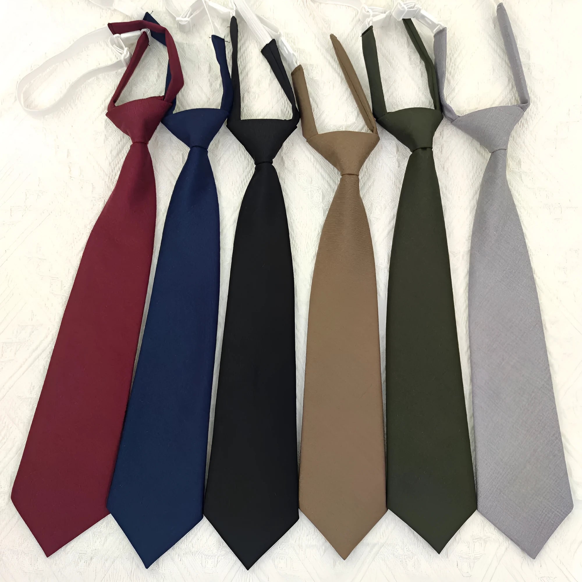 Men's solid navy blue cotton tie on a white background, showing its arrow shape and dimensions.