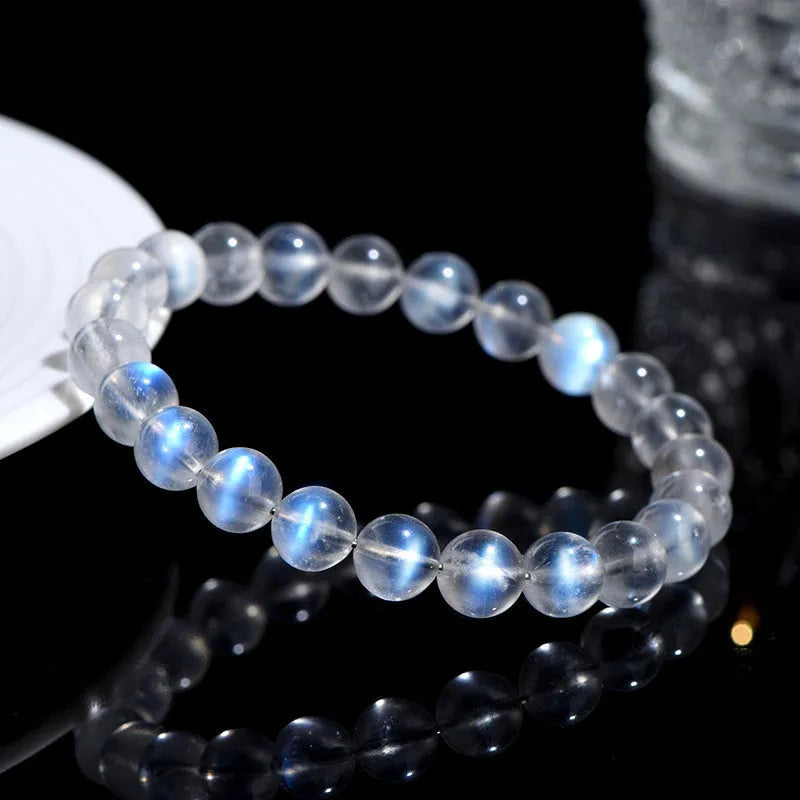 Natural blue moonlight cream body crystal bracelet on wrist, showing single strand of polished beads.