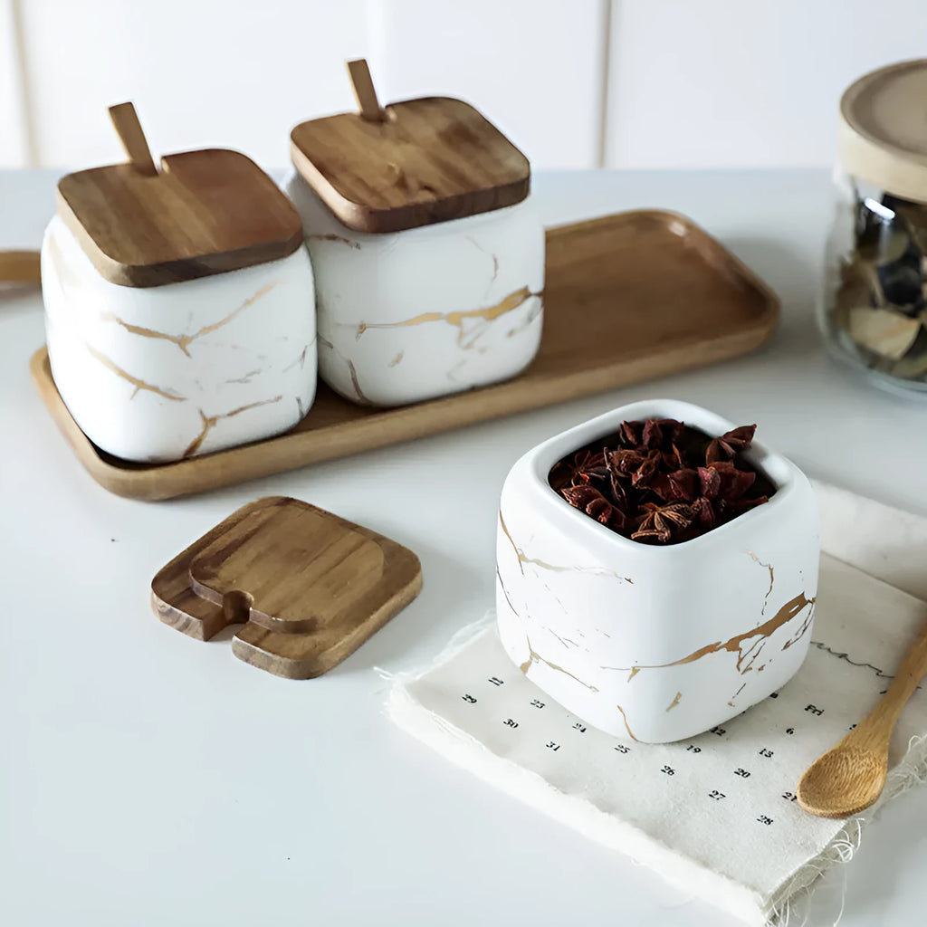 Nordic gold marble ceramic jar set with wooden tray and bamboo spoon on a kitchen counter