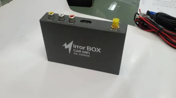 Black car mirror link box Wi-Fi A/V converter with power cable, antenna, AV cable, and manual for smartphone screen mirroring.
