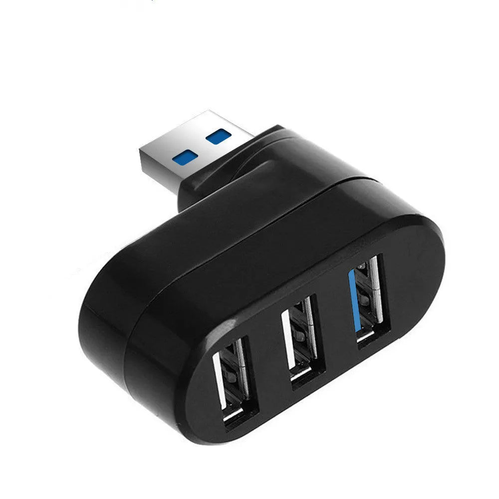 Black or white 4-port USB hub on a desktop next to a laptop and various peripherals.