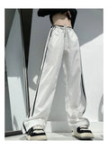 Women's loose straight-leg trousers with contrast ribbon detail in navy blue.