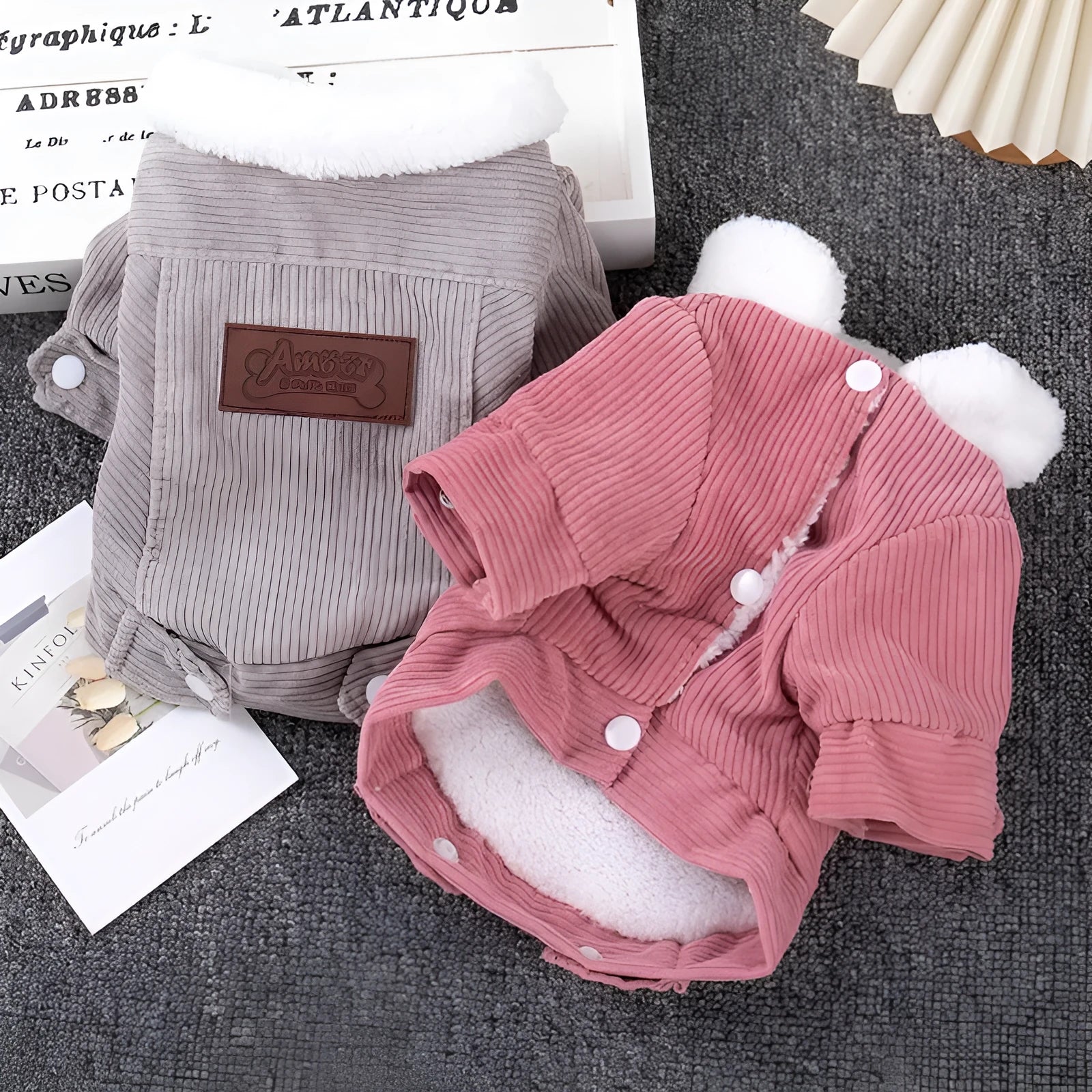 A grey lambswool fleece-lined vest for dogs on a hanger, showing its soft lining and size label.
