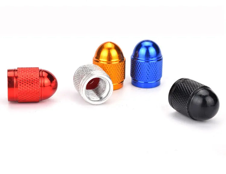 A single aluminium mountain bike tyre valve cap shown in a choice of five colours: black, blue, gold, red, and silver.