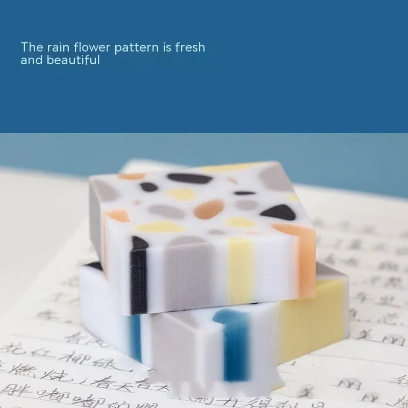 A rectangular brick-shaped white rubber eraser for removing pencil marks.